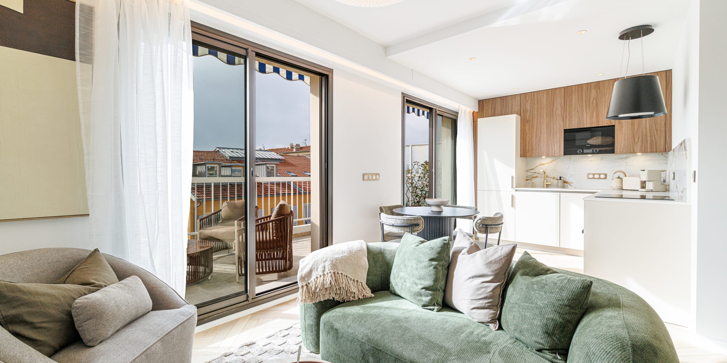 Salon lumineux et cuisine de l’appartement Mamabaldi à Nice